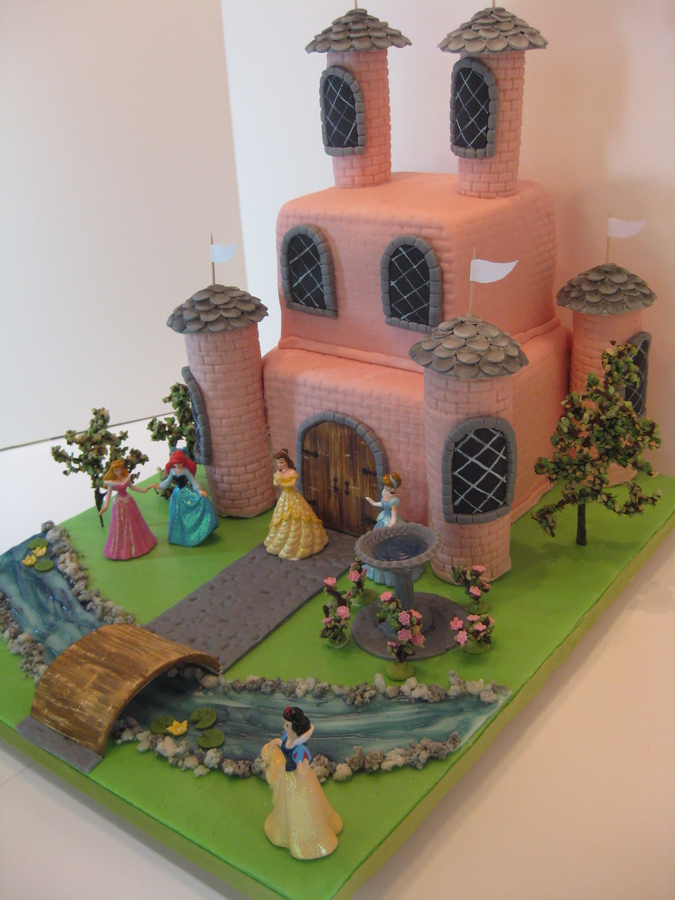 Emma couldn't decide which Disney princess was her favorite, so all were invited to the party at the pink castle. Since this is a friendly castle, there is no drawbridge over the piping gel moat--- rather, a welcome bridge. The cake is WASC with strawberry buttercream, and strawberry MFF over white ganache. The towers are RKT topped with gumpaste slates. The trees and rosebushes are chocolate covered grape stems dipped into green rice krispies for leaves. Water lilies and roses are gumpaste, as is the birdbath filled with piping gel. I had so much fun making this cake that I had to hold myself in check, not to over-do. The client provided the figurines.