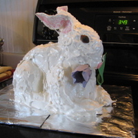 The body of the bunny was a peanut butter cake, the head and legs were peanut butter RKT. The ears were pastillage and the tulip and the bunny's eyes and nose were gumpaste. I had a real problem keeping the ears upright. Next time I'll start earlier and give them more time to dry. I used a vanilla seven minute frosting to cover the whole and give the impression of fur.
