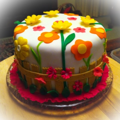 A Choc Hazlenut Cake With Sunflowers Orange Canna Lillys In A Child Like Simplicity A Picket Fence With Birds On It And Pink Primula And A Choc Hazlenut Cake With Sunflowers Orange Canna Lillys In A Child Like Simplicity A Picket Fence With Birds On It And Pink Primula And