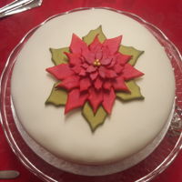 Poinsetta Christmas Cake Rich fruit cake covered with marzipan and white fondant. Gum paste poinsetta.