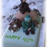 Hunter_Cake.jpg Fondant covered, fondant figures, plastic gun and sign.