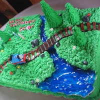 Thomas The Tank Engine Cake For my younger son's 3rd birthday. Grass is buttercream. Trees are ice cream cones with royal. Rocks, flowers, tracks are fondant. (...