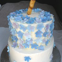 Bamboo And Flowers Vanilla cake with raspberry mousse filling, iced in vanilla buttercream and decorated with gumpaste flowers in shades of blue and dusted...