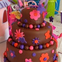 Jasmin's First Birthday Cake Brown Pink Purple Orange Flowers Butterflies Three tier cake covered in chocolate fondant with pink, orange and purple fondant accents. Thanks for looking.