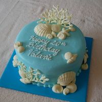 Ocean Theme Birthday Cake Simple round cake decorated with white chocolate molded shells and coral.