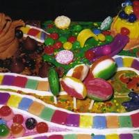 Candyland White cake with buttercream icing. The board is hand painted with fondant characters and game pieces. Lots of candies to complete the look...