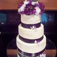 Purple Wedding Cake German Chocolate cake with buttercream . Dark purple ribbon border and silk flowers.
