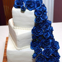 Ryan And Olivia's White buttercream with midnight blue gumpaste roses cascading down.