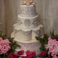 Wedding Covered in marshmallow fondant. Piping in royal icing, gumpaste bow,luster dust painting