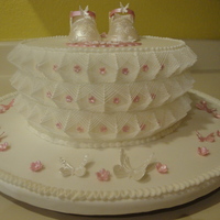 Stringwork Baby Cake Covered in fondant - royal icing stringwork, gumpaste baby shoes.