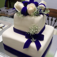 Navy Blue Cake 2 tier square with navy blue ribbon and bows and fresh flowers
