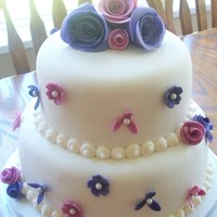 Pink And Purple Flowers cake is French Vanilla with a Caramel buttercream filling. Fondant covered, with buttercream border, fondant flowers with edible pearls,...