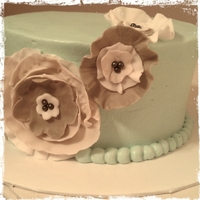 Blue Cake W/ Fondant Flowers 6 inch buttercream with tan and ivory fondant flowers. More practice with a dismal array of tools.