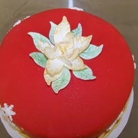 Fondant Covering With Gumpaste Poinsettia On Top And Gumpaste Snowflakes On The Sides Fondant covering with gumpaste poinsettia on top and gumpaste snowflakes on the sides.