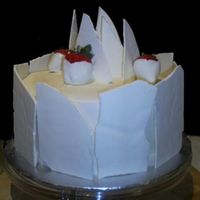 White Chocolate Shard Cake Cake with white chocolate shards and chocolate dipped strawberries.