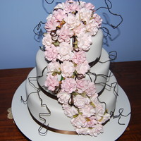 Round Wedding Cake With Pink Roses 3 tier Round cake with Pink paper roses. Chocolate mucake top and bottom, middle was caramel mudcake.