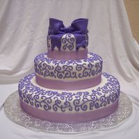 Shades Of Purple This was a wedding cake for a bride who wanted several different shades of purple. Fondant with royal icing scroll work and fondant bow....