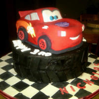 Fast As Lightning!! Carved chocolate car cake on top of a 10" round . Buttercream, Fondant. Fondant covered board, TFL!