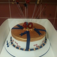 40Th Birthday Exploding Star Cake 12 inch caramel mudcake with dark chocolate ganache. Hand painted gold lid with hand painted red flowers around the side. Design matched...