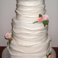 Lisa's Wedding 3 tier (6,8,10) covered in buttercream and then in strips of fondant overlapping each other. Sugar crystals cover the top of each tier and...