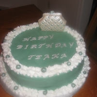1351107449.jpg Buttercream with chocolate purse. Lettering and balls are fondant.