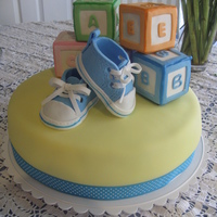 Baby Shower 12" vanilla, bc and cove.red in fondant. The blocks are made with rice cereal treats and decorated in fondant. Baby shoes were made...