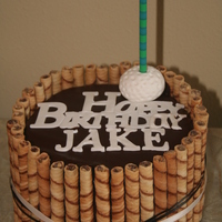 Golf Theme Birthday Flourless chocolate cake with raspberry filling, swiss butter cream, covered with ganache and cookies around the side. I tied a simple...
