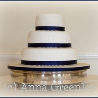 Round Diamante And Blue With Iced Accents Simple cake with diamante ribbon and iced accent dots.
