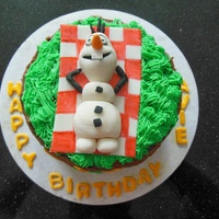 Olaf Birthday Cake Chocolate cake with fondant Olaf on a fondant blanket and buttercream grass.