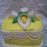 Calla Lily Cake This is a 5 inch square cake covered in yellow buttercream with fondant calla lilies on top. The scallops on the side are also made of...