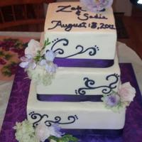 Purple Themed Cake With Fresh Flowers Bride Wanted Their Names And The Date On Top With Purple Scroll Work *Purple themed cake with fresh flowers. Bride wanted their names and the date on top with purple scroll work.