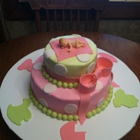 2 Tier Baby Shower 2 Tier baby shower cake. White cake with buttercream icing. Fondant bow and gumpaste baby. Fondant decorations around the board.