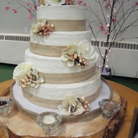 "rustic" Themed Wedding Cake Banana cake with caramel creamcheese filling, buttercream icing. Trimmed with burlap ribbon, and silk flowers(bride's choice)