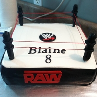 Wwe WWE wrestling cake, used black fondant on sides and dowel rods covered in fondant for poles. took Red string and pulled them tight.