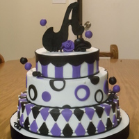 Purple And Black Birthday three tier cake covered in buttercream with fondant accents. The monogram is handcut from fondant. Thanks for looking!