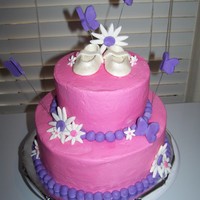 Baby Booties And Butterflies White cake with buttercream and MMF accents. Boo ties are made of gumpaste and dusted with pearl