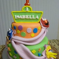 Girly Sesame Street Cake Two tier cake (9" and 6"). One layer chocolate and one layer vanilla on each tier. The characters were made with white chocolate...