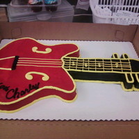 Red And Black Electric Guitar Cut and shaped from a half sheet of white cake, buttercream icing.