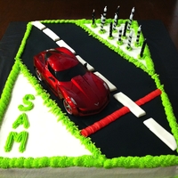 Race Car Cake simple design. Sheet cake iced with buttercream with fondant road and added a plastic race car.