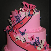 Butterflies 9" and 6" chocolate cake with chocolate buttercream filling and pink buttercream finish. Butterflies are gumpaste cut with the...