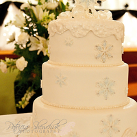 Winter Wedding Cake white fondant with very lightly dusted blue filigree snowflakes, isomalt baubles and and isomalt topper