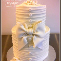 Horizontal Textured Buttercream This is a six inch tall 8 inch and 6 inch cake. It is all buttercream with a fondant bow, ribbon flowers, and buttons.