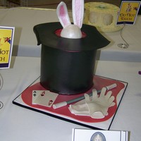 Magician's Table Two tiered magician's top hat, gumpaste brim. 50/50 gumpaste/fondant rabbit head, cards, gloves and magic wand.