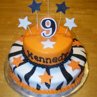 Simple Zebra/star Birthday 10 inch and 6 inch yellow cake with vanilla cream frosting, black fondant zebra stripes, gumpaste stars,and a candy number.