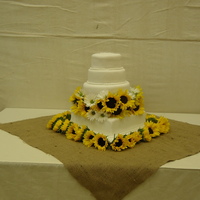 Sunflower Wedding 4 tier wedding cake.pound cake, devil's food chocolate, white velvet and red velvet. Covered in Butter Cream and fondant. Flowers are...