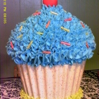 Giant Cupcake Made using chocolate shell for cupcake liner. Sprinkles and cherry are fondant/gum paste mix.