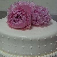 Peonie Wedding Cake Marshmallow fondant, royal icing dots, pink peonies, on layered red velvet cake. Buttercream crumb coat and filling.