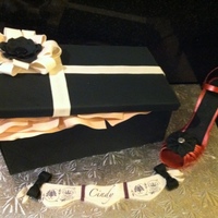 Shoebox And Stiletto Cake Shoebox cake with gumpaste bow, flower, and heal.