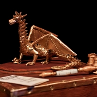 Clockwork Dragon made for a friends wedding the dragons made from gumpaste as are the opera glasses and play program the cake is the wooden box the middle...