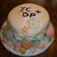 1319309624.jpg Engagement cake for a future wedding on a beach. 9 in WASC w/raspberry filling and raspberry BC. Covered in MMF. Shells are hand painted...